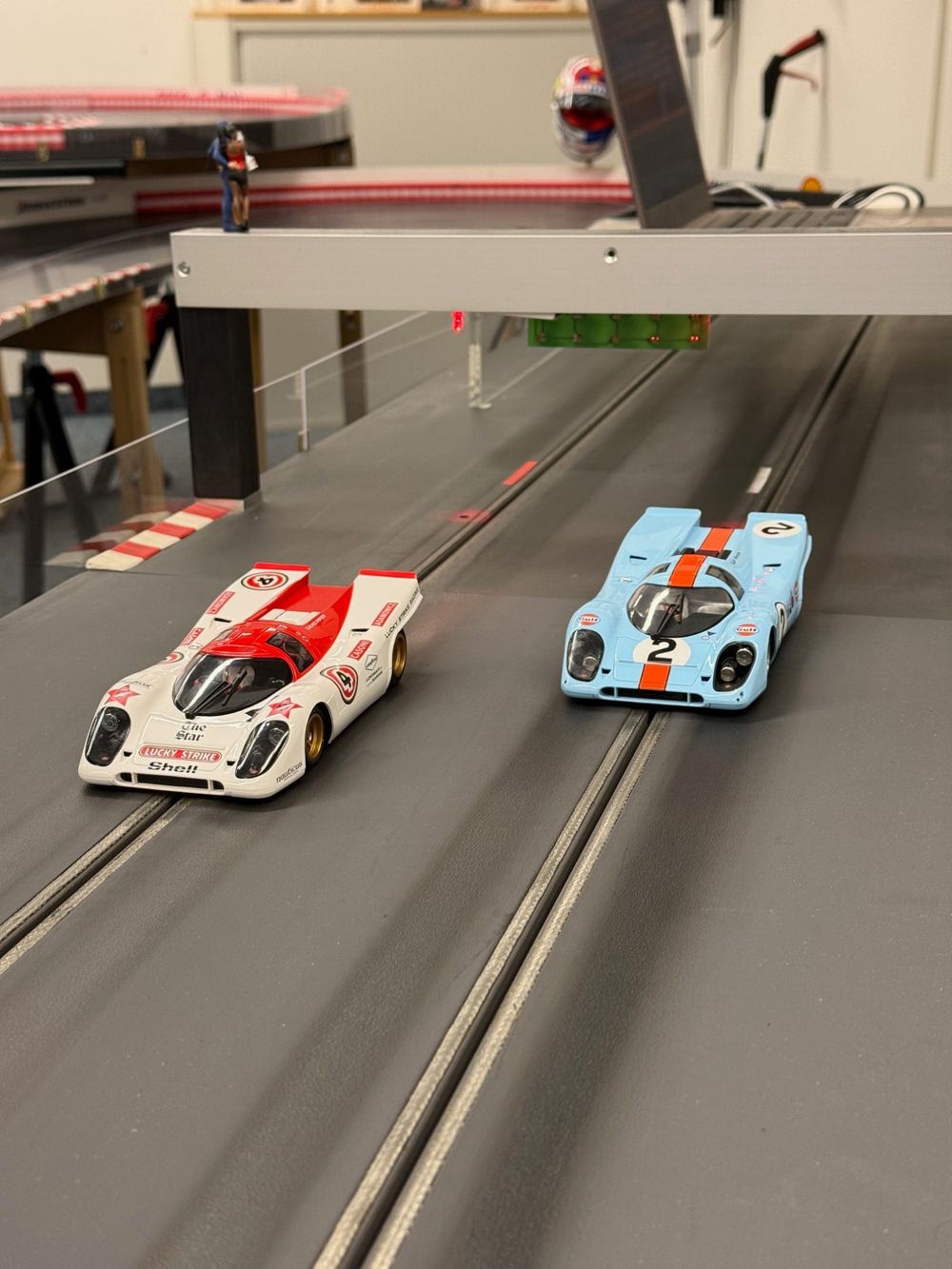 Zwei Porsche 917 auf den Spuren der Rennbahn unter der Startbrücke